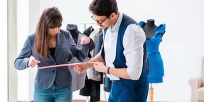 Tailor measuring a client for custom corporate uniform fitting